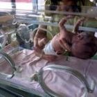 Un recién nacido es cogido por su madre en la incubadora de un centro hospitalario