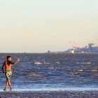 Un joven en una playa del norte de Buenos Aires se refresca debido a la fuerte ola de calor.