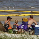 Una familia en una playa con vallas de contención.