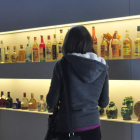 Una mujer observa botellas de tequila en México. SÁSHENKA GUTIÉRREZ