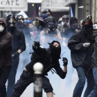 Un grupo de encapuchados lanza objetos contra la policía en París, el 14 de junio.