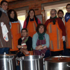 Varias mujeres de la asociación Santa Águeda cocinando las patatas con costilla.