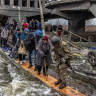 Civiles ucranianos cruzan un puente destruido mientras huyen del asedio en la ciudad de Irpin. ROMAN PILIPEY