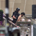 Imagen de un policía británico con uno de los detenidos tras el ataque en el hotel de Glasgow. STRINGER