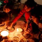 Una familia palestina come a la luz de las velas en la segunda jornada del bloqueo israelí a Gaza