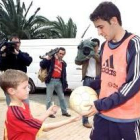 Raúl, que regala un balón a un niño, sigue siendo la principal atracción de la hinchada española