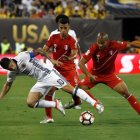 El colombiano James Rodriguez pugna por el balón con los peruanos Alberto Rodriguez y Miguel Trauco.