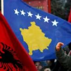 Un grupo de albano-kosovares ondean la nueva bandera de Kosovo (derecha) y la de Albania
