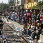 Miles de refugiados esperan un tren que les permita cruzar Macedonia y llegar a Serbia para luego pasar la frontera con Hungría, donde se erige una prolongada valla.