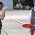 Chacón recibe la bandera entregada por el responsable del contingente español.