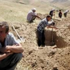 Un grupo de hombres cavan fosas en un monte a las afueras de Andizán