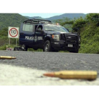 Agentes federales y soldados del Ejército mexicano vigilan una carretera en el municipio de Arteaga.