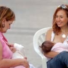 Unas madres defensoras de la lactancia materna alimentan a sus hijos en un acto público
