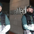 Agentes de la Guardia Civil custodian la sede de la empresa pública Aguas de las Cuencas Mediterráneas (Acuamed), en Madrid, durante el registro de las dependencias.