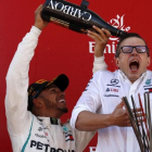 Lewis Hamilton ducha en champaña a Peter Bonnington, uno de sus ingenieros en el equipo Mercedes. /