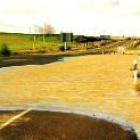 En la foto, la carretera N-120 a su paso por Sahagún cortada ayer por las lluvias