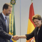 El príncipe Felipe estrecha la mano de la presidenta brasileña, Dilma Rousseff.