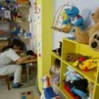 Una trabajadora de Aspace atiende a dos niños afectados por parálisis cerebral