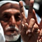 Ancianos palestinos hacen la señal de la victoria