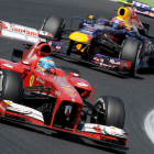El español Fernando Alonso pugna con su Ferrari con el piloto de Red Bull, Mark Webber, durante el Gran Premio de Hungría disputado ayer.