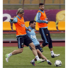 Xavi y Torres pugnan por la pelota, con Piqué al fondo, en el entrenamiento de España.