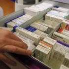 Una farmacéutica leonesa abre un cajón en busca de medicamentos para un cliente
