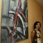 Graciela posa junto a algunos de sus cuadros de la serie bicicletas