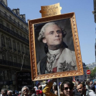 Los manifestantes contrarios a Macron muestran un retrato del rey Luis XIV con la cara del actual presidente.