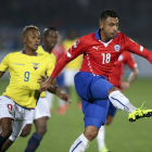 El defensa chileno Gonzalo Jara (d) controla el balón ante el delantero ecuatoriano Fidel Martínez (i).