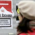 Una joven observa uno de los carteles contra ETA firmados por el PP