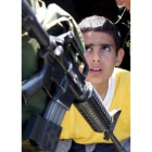Un niño palestino observa a un soldado israelí en el pueblo de Nileen