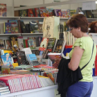 Una mujer ojea un libro en un stand