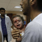 Un palestino acude con su bebé herido a un hospital, este viernes en Gaza.