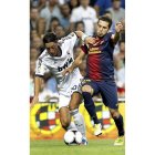 El centrocampista del Madrid Mesut Ozil lucha un balón con el defensa del Barça Jordi Alba.