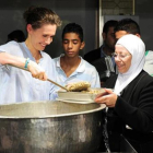 Asma el Asad, en un reparto de comida a huérfanos y desplazados en Damasco, en el 2013.