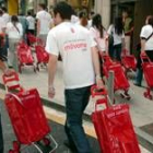 Un grupo de agentes electorales del PSOE, provistos de carros, reparten propaganda electoral