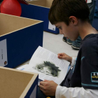 Un niño lee un libro en una feria de la capital leonesa. RAMIRO