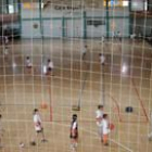 Unos niños juegan al baloncesto en un polideportivo