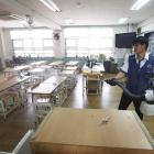 Un empleado desinfecta un aula de una escuela primaria de Seúl.