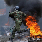 Un agente antidisturbios salta una barricada en llamas levantada por seguidores del opositor Raila Odinga, en Mathare (Nairobi), el 12 de agosto.