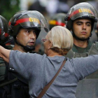 Una manifestante de la oposición se encara con la policía durante una protesta contra el Gobierno de Maduro, el lunes en Caracas.