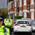 Agentes británicos mantiene un cordón policial en la calle residencial del noroeste de Londres donde tuvo lugar el tiroteo durante una operación antiterrorista, el 28 de abril, en Londres.