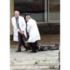 Dos médicos sacan el cadáver de la rehén asesinada por los chechenos