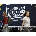 Varias personas caminan junto a la decoración sobre las elecciones al Parlamento europeo en Bruselas.