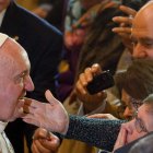 Una creyente estira el brazo para tocar al papa al final de la ceremonia de vigilia en Roma.
