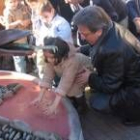 El alcalde sostiene a una de las niñas que dejaron sus huellas en el monumento