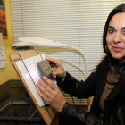 Esther Gallego Villegas en el aula de rehabilitación de la ONCE en León con una lupa para personas con baja visión.