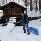 Un vecino de Lario espala nieve en una finca de su propiedad.