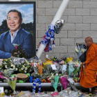 Un monje budista deja unas flores junto a la fotografía del empresario, a las afueras del estadio del Leicester.