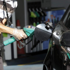 Un hombre reposta carburante en su vehículo en una estación de servicio española.